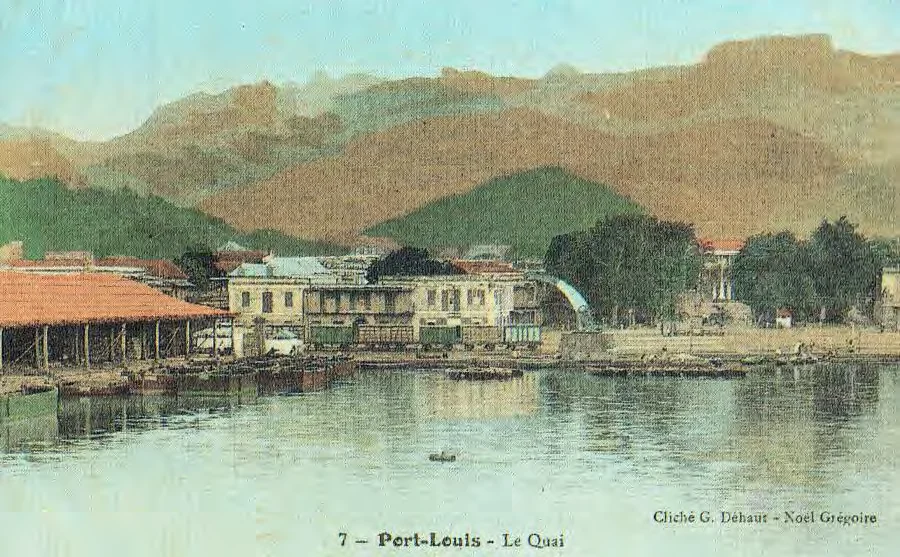 Carte postale ancienne colorisée du quai de Port-Louis, montagnes en arrière-plan